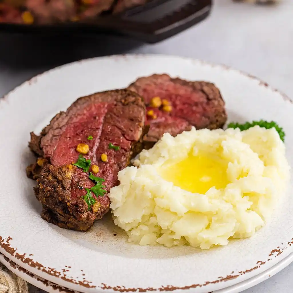 Minimalist Christmas beef tenderloin roast sliced on white marble
