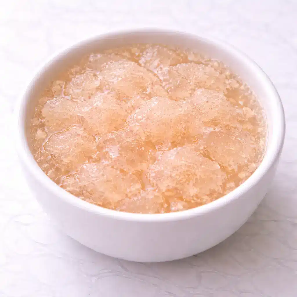 Gelatin Trick Recipe drink in clear glass mug on white marble surface