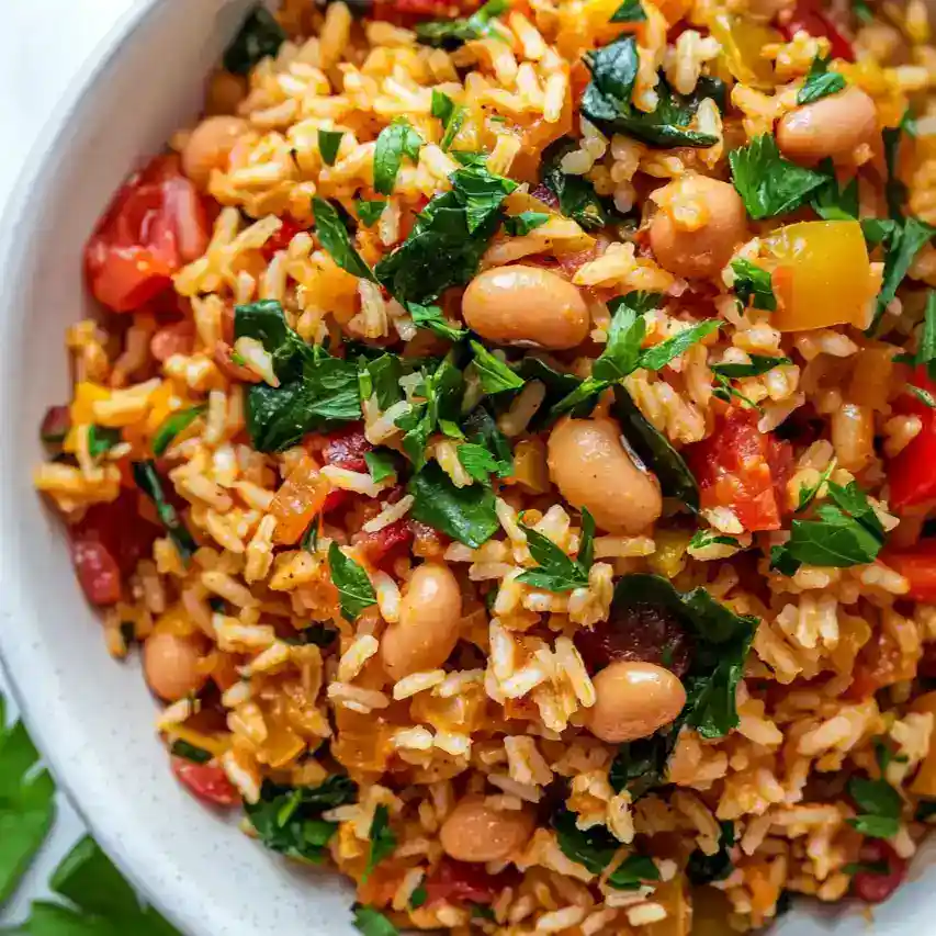 healthy mediterranean rice and beans served in white bowl with chickpeas olive oil and fresh parsley