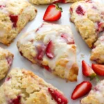 Two quick strawberries and cream scones on a white porcelain plate next to coffee.