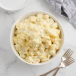 Creamy Potato Salad Recipe garnished with fresh dill and paprika.